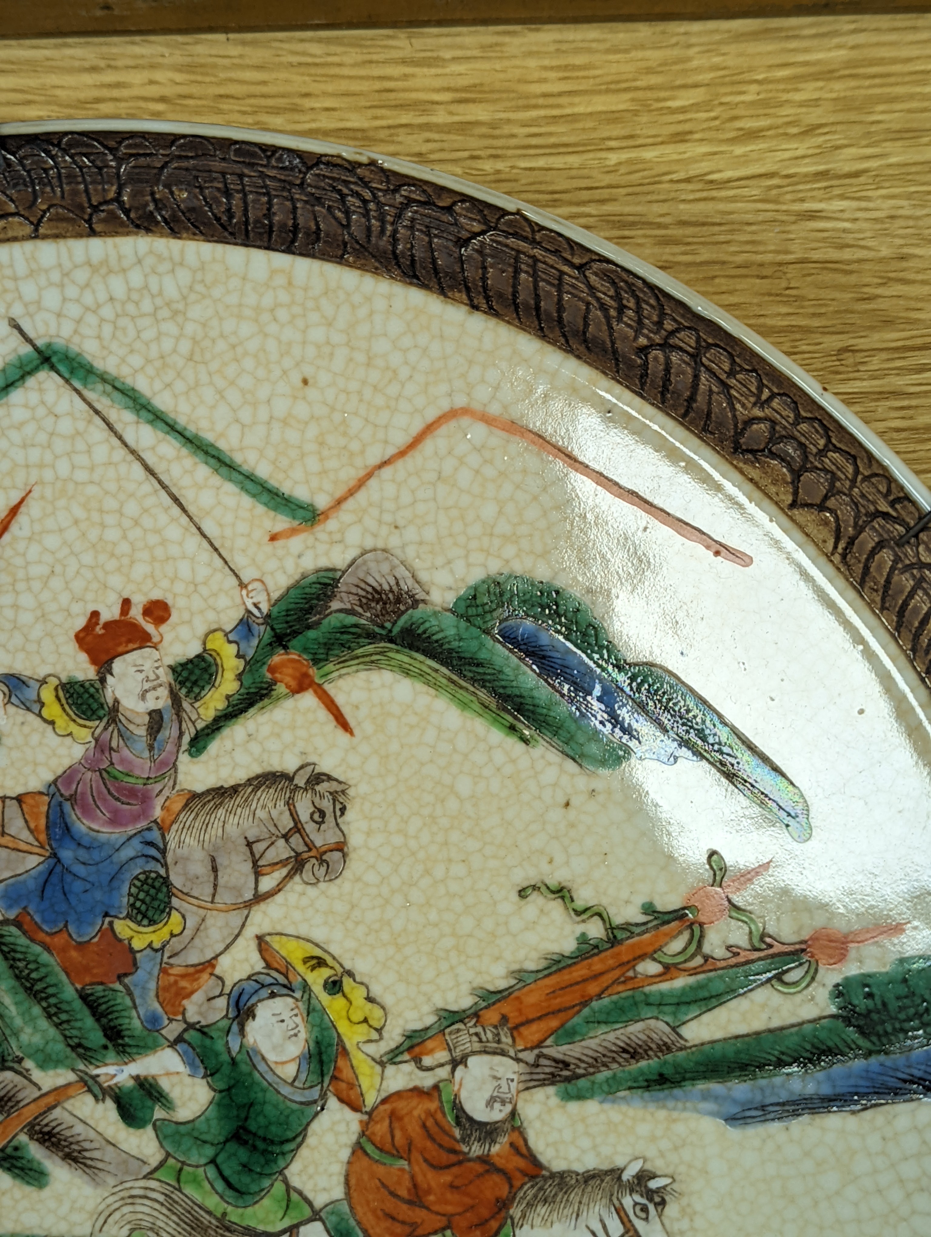 A Chinese crackle glaze dish, early 20th century, depicting a battle scene 33cm